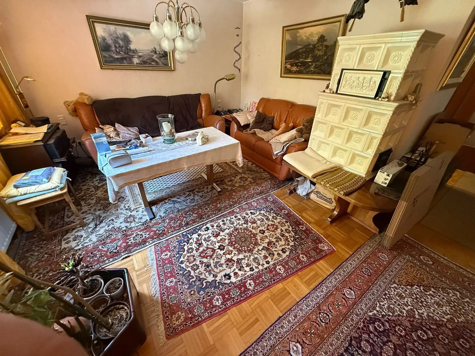 Wohnzimmer mit Sofa, Sesseln und Kachelofen vor der Haushaltsauflösung in Duisburg - Vorher-Foto der Rümpelmannschaft