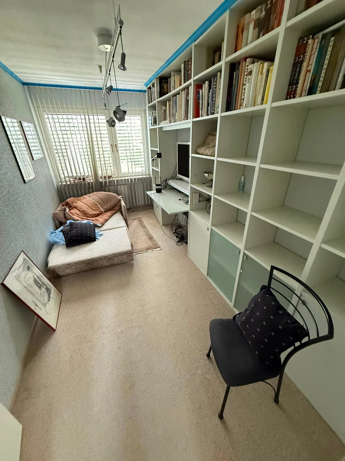 Möbliertes Zimmer mit Regalwand und Sessel vor der Entrümpelung in Velbert